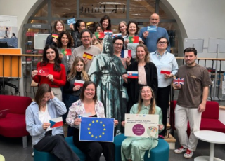 Photo du groupe prise lors d'une staff week, chaque participant présente un drapeau de leur pays